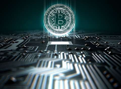 Electronic circuit board overlaid with a physical Bitcoin cryptocurrency